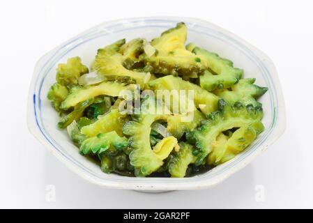 Südostasiatischer, Myanmar oder indischer traditioneller Bitter-Kürbis (Karela)-Kurren in weißer Schale. Isoliert auf Weiß. Stockfoto