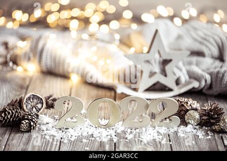 Das Winterstillleben mit der dekorativen Nummer des kommenden Jahres auf der hölzernen Oberfläche mit den dekorativen Elementen vor dem verschwommenen Hintergrund. Stockfoto