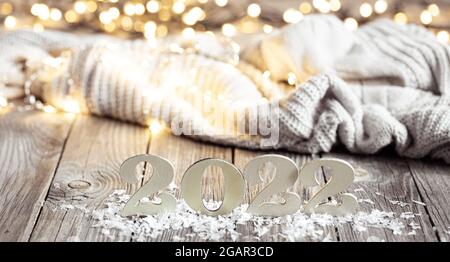 Das Winterstillleben mit der dekorativen Nummer des kommenden Jahres auf der hölzernen Oberfläche mit den dekorativen Elementen vor dem verschwommenen Hintergrund. Stockfoto