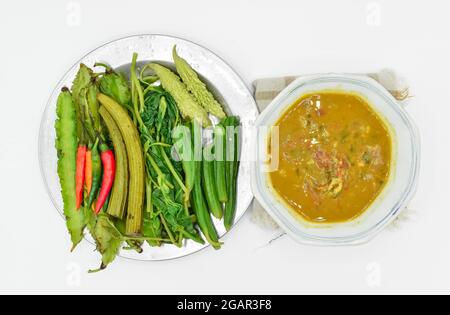 Myanmar oder Burma traditionelle Fisch Erhaltung Sauce, Ngapi Yay und frisches Gemüse, Chilies, Flasche Kürbis Blätter, bitteren Kürbis, flache grüne Erbsen in st Stockfoto