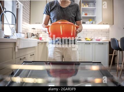 Ein Mann hält ein Gericht in den Händen, bevor er es in den Ofen stellt. Stockfoto