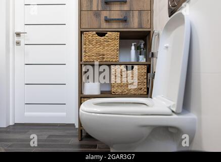 Weißes Badezimmer mit Toilette und Strohdetails. Stockfoto