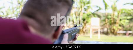 Im Schießstand der Straße schießt ein Mann eine Waffe auf das Ziel Stockfoto