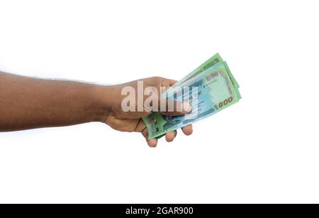 Fünfhundert Taka-Banknoten aus Bangladesch halten eine Hand auf weißem Hintergrund Stockfoto