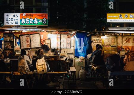 Fukuoka, Japan - Yatai, ein kleiner, mobiler Imbissstand in Japan, der normalerweise Ramen oder andere Lebensmittel verkauft. Der Stand wurde nachts auf Fußgängerwegen aufgestellt. Stockfoto