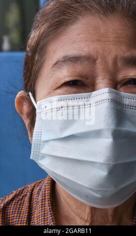Südostasiatische, Erwachsene ältere Frau aus Myanmar, die während der Pandemie COVID-19 eine blaue OP-Maske oder eine medizinische Maske trägt. Prävention von Corona-Virus, dro Stockfoto