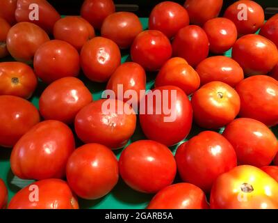 Frische und reife rote Tomaten auf grünem Hintergrund. Rote Früchte Muster. Stockfoto