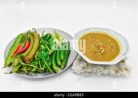 Myanmar oder Burma traditionelle Fisch Erhaltung Sauce, Ngapi Yay und frisches Gemüse, Chilies, Flasche Kürbis Blätter, bitteren Kürbis, flache grüne Erbsen in st Stockfoto