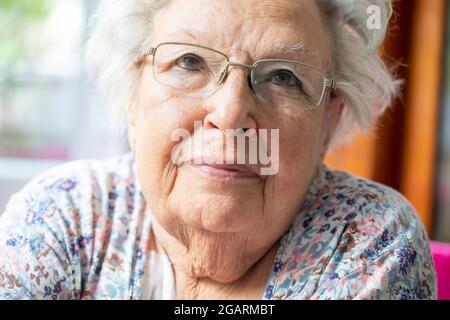 Porträt einer schönen alten Frau mit grauen Haaren und Brille Stockfoto