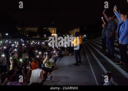 Washington, DC, USA. August 2021. Im Bild: Demonstranten bei einer Mitternachtskundgebung auf den Stufen des Kapitols halten ihre Telefone in der Luft auf Anfrage der Kongressabgeordneten Cori Bush (D-MO), in einem Moment des Schweigens, um sich an diejenigen zu erinnern, die aufgrund der Obdachlosigkeit und der Pandemie verloren gegangen sind. Hinter ihr stehen die Vertreter Alexandria Ocasio-Cortez (D-NY), Jamaal Bowman (D-NY) und Sara Jacobs (D-CA). Die Kongressabgeordnete Bush rief die Kundgebung an, um gegen das Ende des Räumungsmoratoriums am 1. August um Mitternacht zu protestieren. Kredit: Allison Bailey/Alamy Live Nachrichten Stockfoto