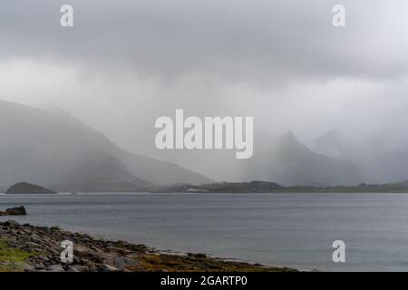 Ein mystischer Fjord und Atlantischer Ozean an einem bewölkten und nebligen Sommertag auf den Lofoten-Inseln im Norden Norwegens Stockfoto