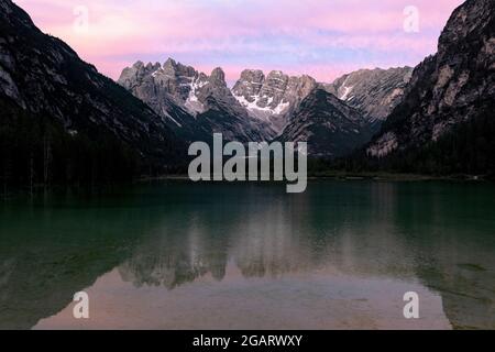 Der Landrosee (Durrensee) unter dem rosa Himmel bei Sonnenaufgang mit dem Monte Cristallo im Hintergrund, Dolomiten, Südtirol, Italien Stockfoto