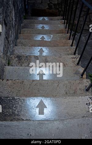 Schablonierte Pfeile, die Treppen hinunter zu einem Keller in der New Town, Edinburgh, Schottland, Großbritannien zeigen. Stockfoto