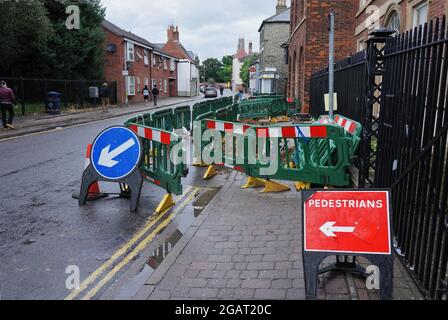 Straßenarbeiten mit grünen Barrieren, die Fußgänger um ein Loch im Bürgersteig auf der High Street in BOSTON Lincolnshire ablenken. Stockfoto