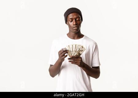 Porträt von coolen afroamerikanischen Kerl in Beanie Geld zählen, stehen weißen Hintergrund Stockfoto