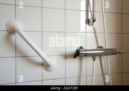 Dusche und Handlauf, Haltegriff für ältere Menschen im Bad im Krankenhaus oder Altersheim, Sicherheit und medizinisches Konzept Stockfoto