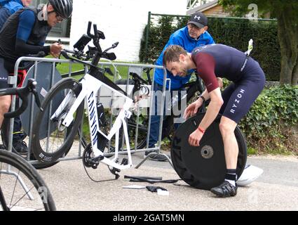 Maastricht, Niederlande. August 2021. Jan-Ole Gerschefski (Startnr 1261) von Deutschland, die während des Ironman 70.3 Maastricht-Limburg Triathlon einen Platten Reifen an der Seite der Strecke festgemacht hat. Aufgrund des schnell fließenden Wassers in der Maas nach den jüngsten Überschwemmungen wurde der Schwimmabschnitt der Strecke durch einen zusätzlichen Laufabschnitt ersetzt, was den Triathlon zu einem Run-Bike-Run-Event machte. Anna Karpendale/Alamy Live News Stockfoto