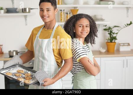 Afroamerikanischer Bruder und Schwester mit leckeren hausgemachten Keksen in der Küche Stockfoto