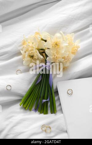 Schönes Bouquet von Narzissen Blumen mit goldenen Ringen auf dem Bett Stockfoto