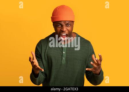 Porträt eines wütenden afroamerikanischen Mannes, der vor Wut vor die Kamera schrie, eines sehr wütenden schwarzen Mannes, der die Hände hob und wütend schrie, während er isola stand Stockfoto