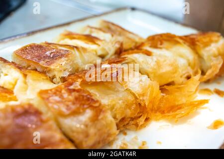 Nahaufnahme des türkischen kol borek (Burek) mit Hackfleisch und Käse, Käse in Scheiben geschnitten und Hackfleisch Patty. Traditionelle Küche Stockfoto