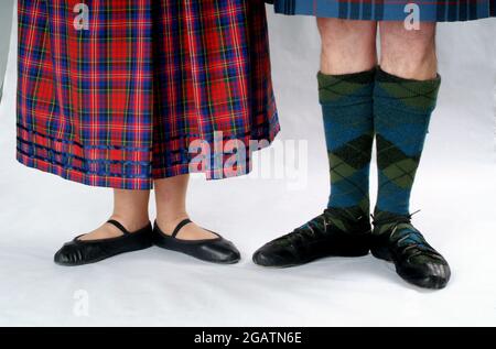 Mann und Frau in schottischer Country Dancing Kleidung. Sie trägt einen Tartan-Rock, er trägt Tartan-Strümpfe. Beide tragen Schuhe, die als Ghillies bekannt sind Stockfoto