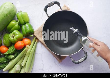 Giessen von Pflanzenöl in die Pfanne. Draufsicht Stockfoto