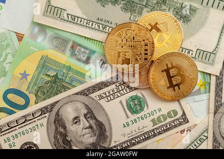 bitcoins auf einem Texturhintergrund aus Euro und Dollar Stockfoto