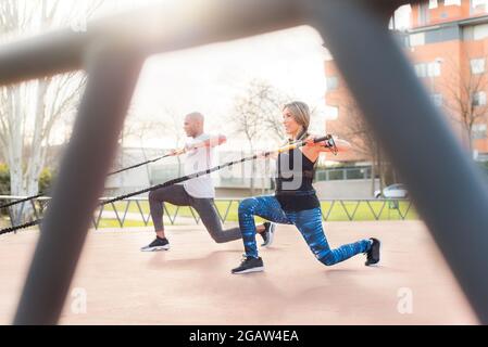 Atlhetic Multi-Ethnic-Menschen trainieren mit einem trx-Fitnessband im Park Stockfoto