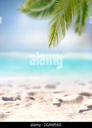 Sand mit verschwommenem Palm und tropischem Strand Bokeh Hintergrund, Stockfoto