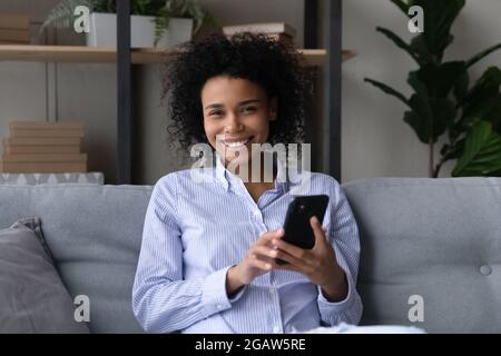 Porträt einer lächelnden afroamerikanischen Frau benutzen Handy Stockfoto