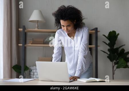 Junge afroamerikanische Frau arbeitet zu Hause am Laptop Stockfoto