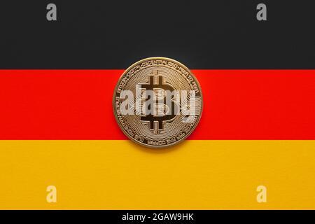 Eine Bitcoin auf einem deutschen Flaggenhintergrund. Das deutsche Gesetz erlaubt es institutionellen Fonds, am 2021. August in Kryptowährungen zu investieren Stockfoto