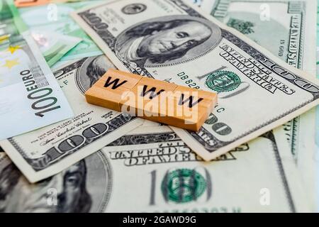 Www-Inschrift auf Holzwürfeln auf der Textur von US-Dollar- und Euro-Banknoten Stockfoto