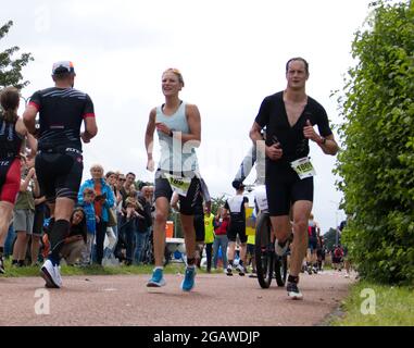 Maastricht, Niederlande. August 2021. Evelien Ruijters aus den Niederlanden führt das Damenrennen während des letzten Teils des Ironman 70.3 Maastricht-Limburg Triathlons an. Aufgrund des schnell fließenden Wassers in der Maas nach den jüngsten Überschwemmungen wurde der Schwimmabschnitt der Strecke durch einen zusätzlichen Laufabschnitt ersetzt, was den Triathlon zu einem Run-Bike-Run-Event machte. Anna Karpendale/Alamy Live News Stockfoto