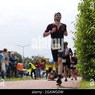 Maastricht, Niederlande. August 2021. Jan-Ole Gerschefski aus Deutschland läuft während des letzten Teils des Ironman 70.3 Maastricht-Limburg Triathlons. Früher verlor er wegen eines Reifenplatts Zeit, reparierte ihn aber und beendete das Rennen. Aufgrund des schnell fließenden Wassers in der Maas nach den jüngsten Überschwemmungen wurde der Schwimmabschnitt der Strecke durch einen zusätzlichen Laufabschnitt ersetzt, was den Triathlon zu einem Run-Bike-Run-Event machte. Anna Karpendale/Alamy Live News Stockfoto