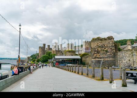 CONWY, WALES - 04. JULI 2021: Blick auf die Promenade von Conwy und das berühmte Conwy Castle aus dem 13. Jahrhundert Stockfoto