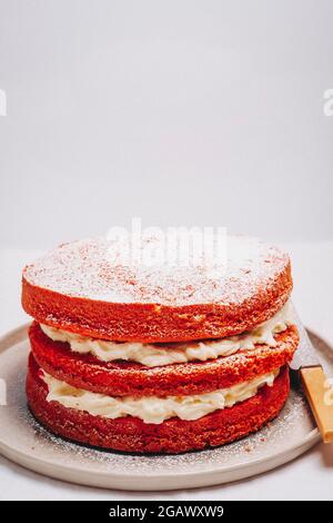 Victoria Sponge Kuchen gefüllt mit Schlagsahne auf einem Teller mit einem Messer auf einem Tisch – FOODPIX WEISS, COPYSPACE Stockfoto