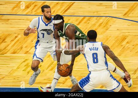 Orlando, Florida, USA, 11. April 2021, Milwaukee Bucks Point Guard Jrue Holiday #21 Versuch, im Amway Center an Orlando Magic's Dwayne Bacon #8 und Michael Carter-Williams #7 zu laufen (Bildnachweis: Marty Jean-Louis) Stockfoto