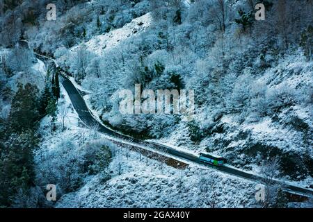 Alpujarras Straße nach einem Schneefall, mit einem Bus im Umlauf. Stockfoto