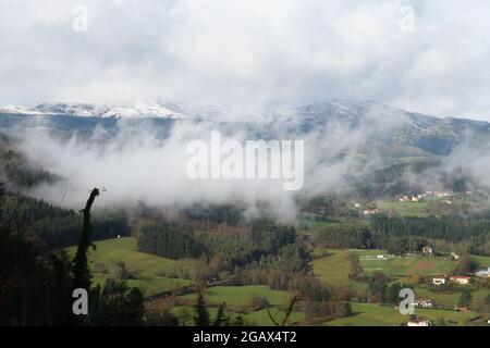 Baskische Täler im Nebel vom verschneiten Berg Kolitxa Stockfoto