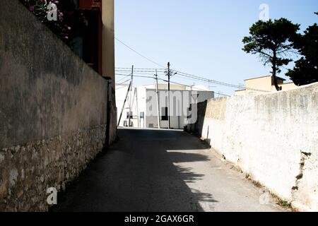 Ein Spaziergang in einem kleinen Dorf in der Nähe von Trapani, Sizilien heiße Straßen, torrides Sommerwetter. Hitze und Schwüle begleiten die Einsamkeit der Vororte. Stockfoto