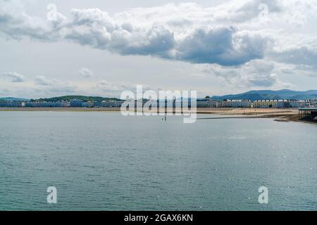 LLANDUDNO, WALES - 03. JULI 2021: Blick auf die kurvige Promenade von Llandudno, gesäumt von Hotels auf der Landzunge Great Orme Stockfoto