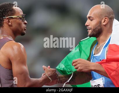 (210801) -- TOKIO, 1. August 2021 (Xinhua) -- Lamont Marcell Jacobs (R) aus Italien reagiert nach dem 100-m-Finale der Männer bei den Olympischen Spielen 2020 in Tokio, Japan, 1. August 2021. (Xinhua/Li Gang) Stockfoto