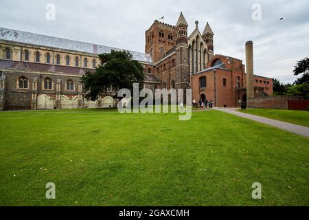 St Albans Cathedral und der streng aussehende Cathedral Gift Shop, dessen letzterer im Jahr 1981 erbaut wurde. Stockfoto