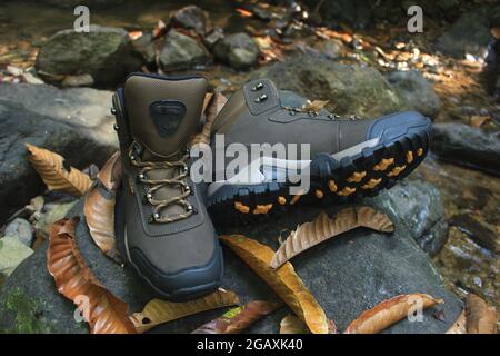 Stiefel mit maskulinem Design für Outdoor-Abenteuer-Aktivitäten, mit gezackten Sohlen, die für tropisches und schneebedecktes Gelände geeignet sind. Stockfoto