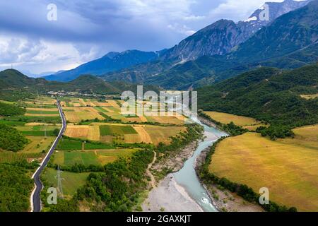 Aus der Vogelperspektive sehen Sie die wunderschöne Landschaft eines kultivierten Plateaus in der Nähe des Flusses Vjosa und der Berge im Stadtteil Permet, albanien Stockfoto
