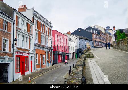 Londonderry, Nordirland, Juli 2016. Die farbenfrohen Gebäude entlang der Straße in der Nähe der Derry City Wall. Stockfoto