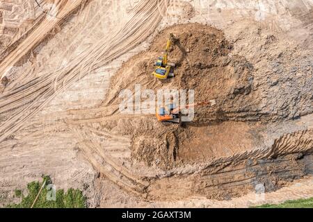 Zwei Bagger arbeiten auf der Baustelle auf Erdarbeiten. Schwere Baumaschinen. Luftaufnahme. Stockfoto