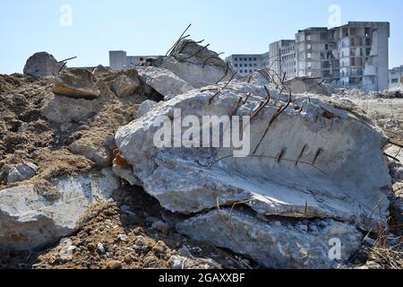 Die Überreste des zerstörten Gebäudes einer großen Industrieanlage. Der zerstörte Balken mit dem hervorstehenden Anker liegt im Vordergrund. Backgrou Stockfoto